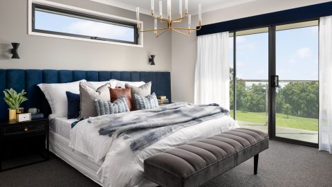 A bedroom with light coming through aluminium sliding doors