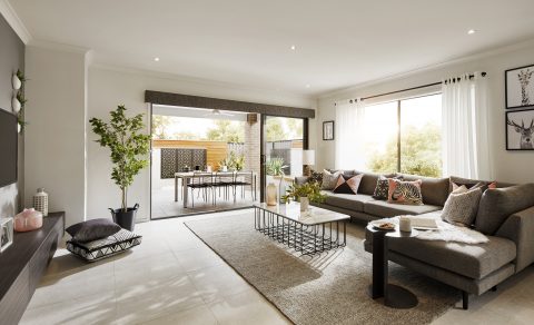 A lounge room opening through aluminium sliding doors into an outdoor area for entertaining guests